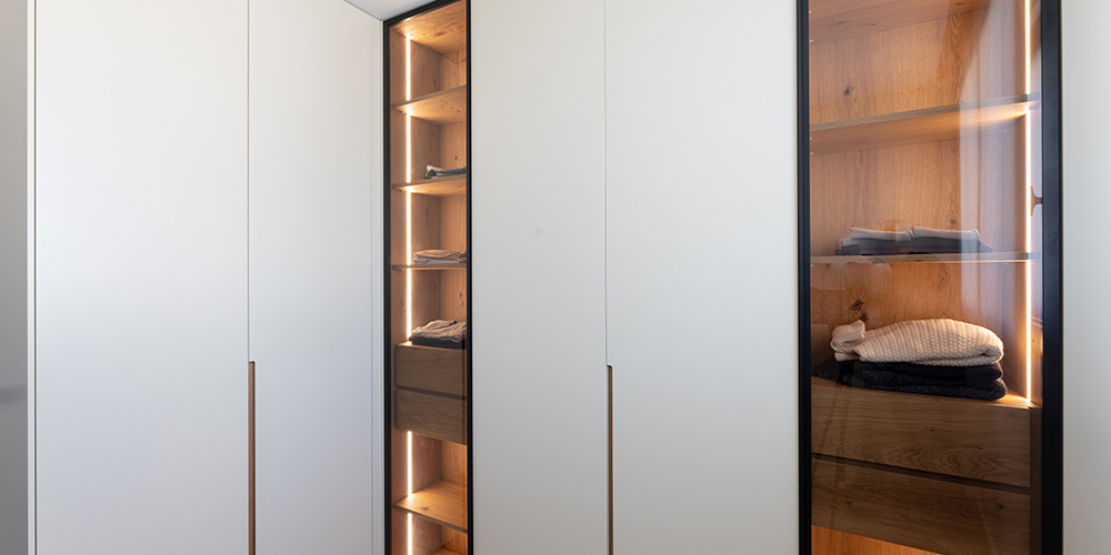 Vestidor a mida amb portes lacades i vitrines decoratives