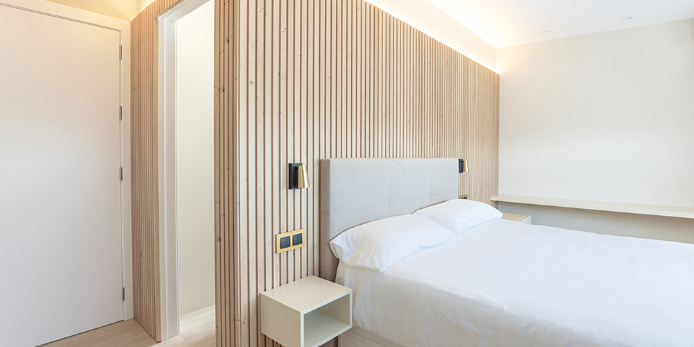 Vista dormitori amb vestidor a mida amb porta oculta oberta